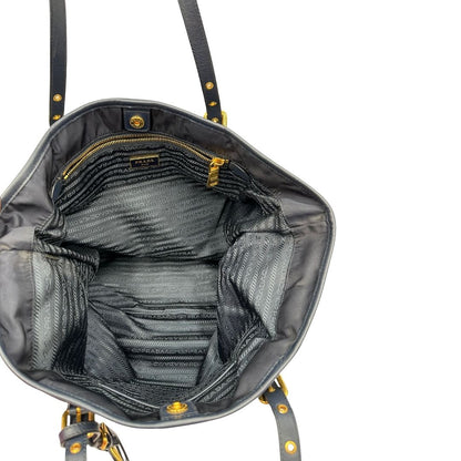 Interno di una borsa Prada in nylon blu navy e finiture in pelle saffiano tono su tono, con parti metalliche dorate; munita di un accessorio porta address e doppi manici leggermente regolabili. Indossabile a spalla. Completa di dustbag e card d'autenticità.