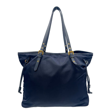 Retro di una borsa Prada in nylon blu navy e finiture in pelle saffiano tono su tono, con parti metalliche dorate; munita di un accessorio porta address e doppi manici leggermente regolabili. Indossabile a spalla. Completa di dustbag e card d'autenticità.