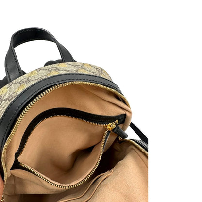 Tasca interna di un Zaino Gucci in canvas GG beige con finiture in pelle nere e parti metalliche dorate; presenta una stampa di api dorate su tutta la superficie, munito di un manico e bretelle in tessuto regolabili. Originale, usato, di lusso, in ottime condizioni.
