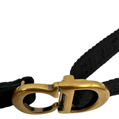 Cintura Christian Dior in tessuto logato nera, impreziosita da fibbia con CD in metallo dorato. Completa di dustbag. Chiusura a cricchetto.