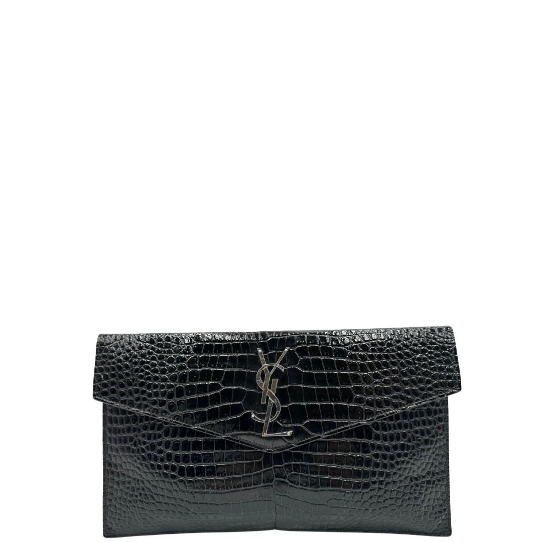 Front di una pochette Saint Laurent in pelle nera lucida effetto cocco, impreziosita dal logo Cassandre sul front in metallo argentato. Munita di dustbag.