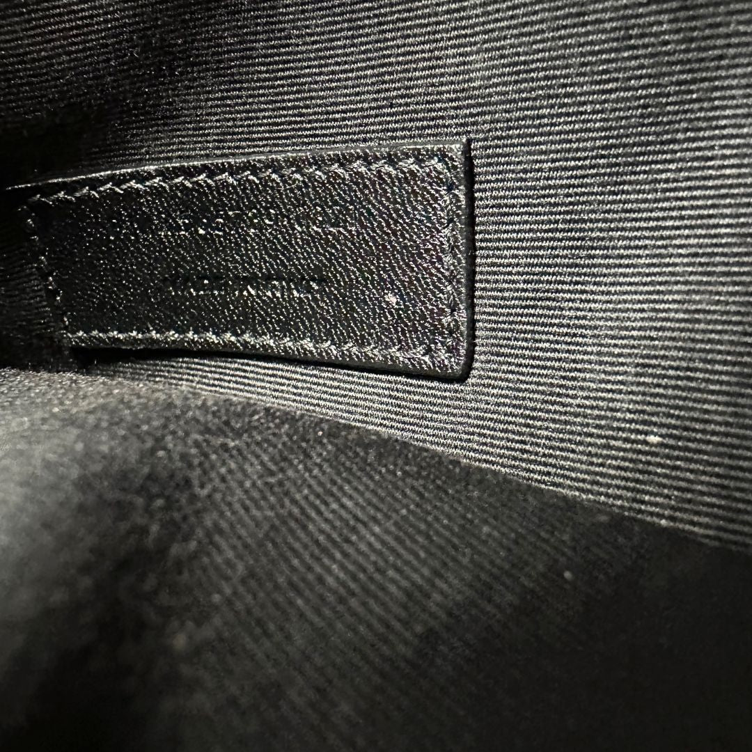 Codice di una pochette Saint Laurent in pelle nera lucida effetto cocco, impreziosita dal logo Cassandre sul front in metallo argentato. Munita di dustbag.