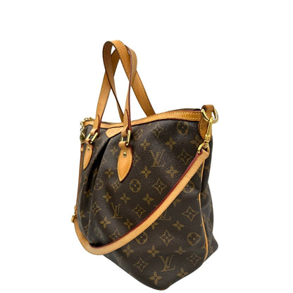 Laterale destro di una borsa Louis Vuitton in canvas marrone monogram con parti metalliche dorate e finiture in vacchetta naturale; munita di una tracolla amovibile e regolabile e doppi manici. Indossabile a spalla oppure a mano.