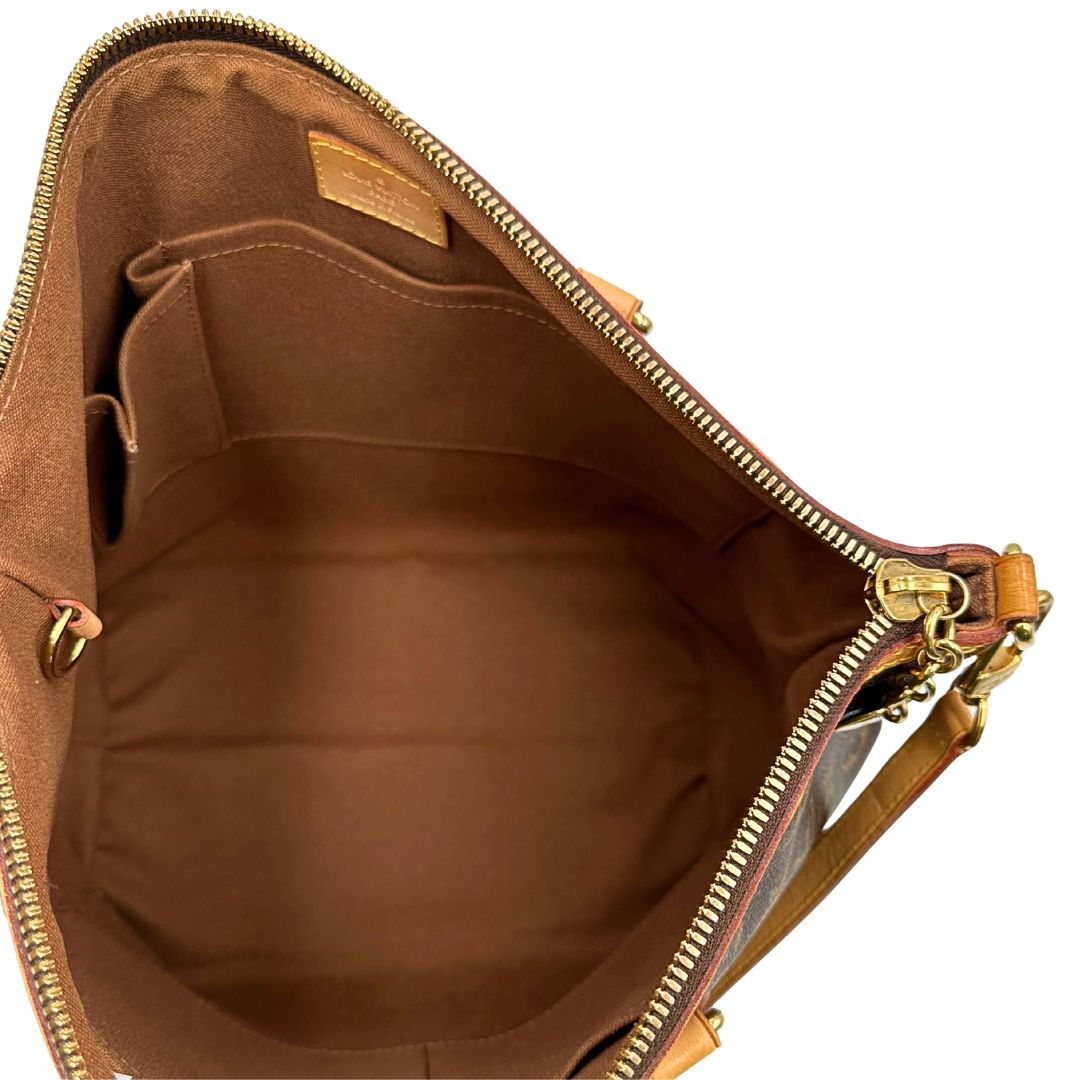Interno di una borsa Louis Vuitton in canvas marrone monogram con parti metalliche dorate e finiture in vacchetta naturale; munita di una tracolla amovibile e regolabile e doppi manici. Indossabile a spalla oppure a mano.
