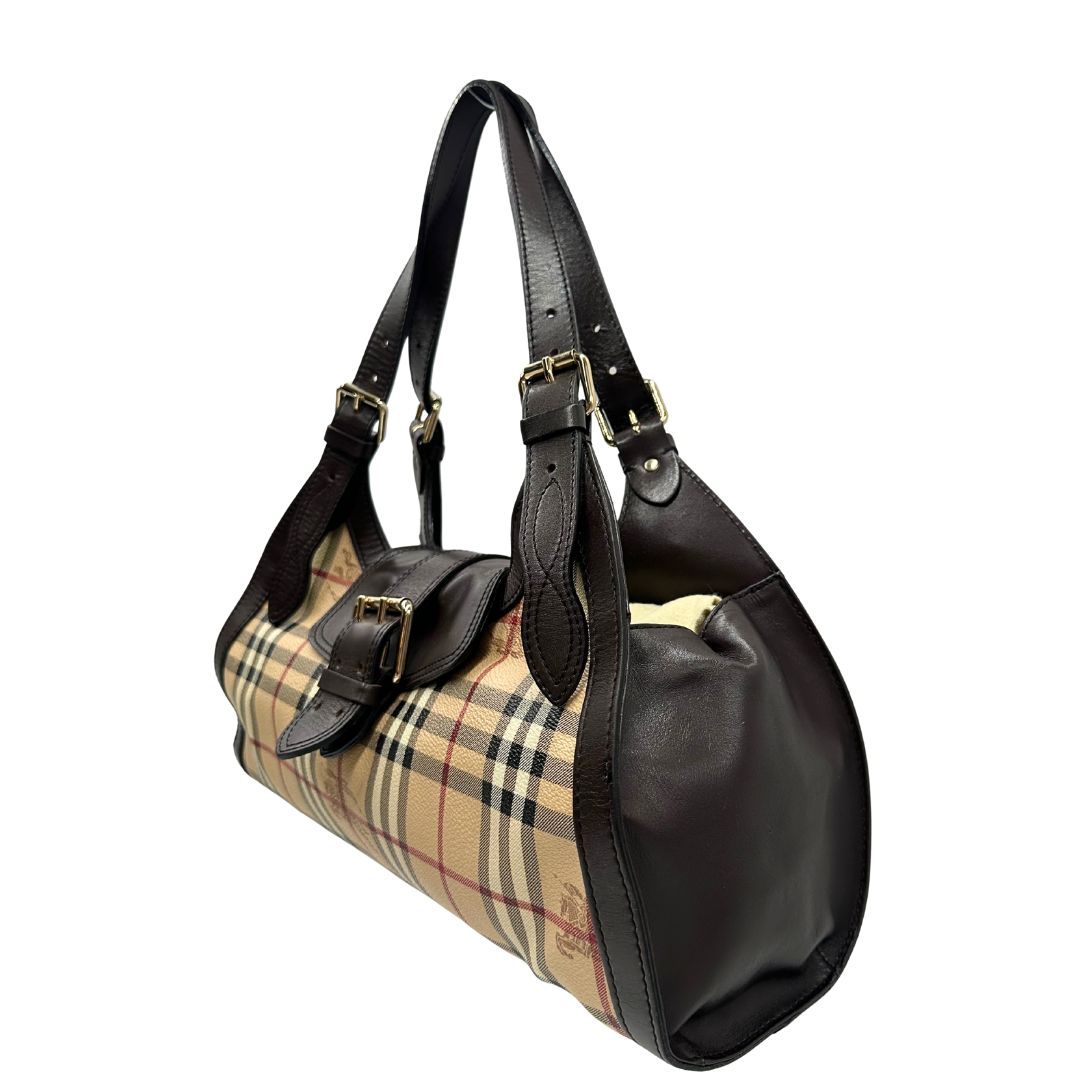 Laterale destro di una borsa Burberry in canvas beige, motivo Burberry check, con dettagli e finiture in pelle marroni testa di moro, parti metalliche dorate. Munita di doppi manici leggermente regolabili, indossabile a spalla. Completa di dustbag.