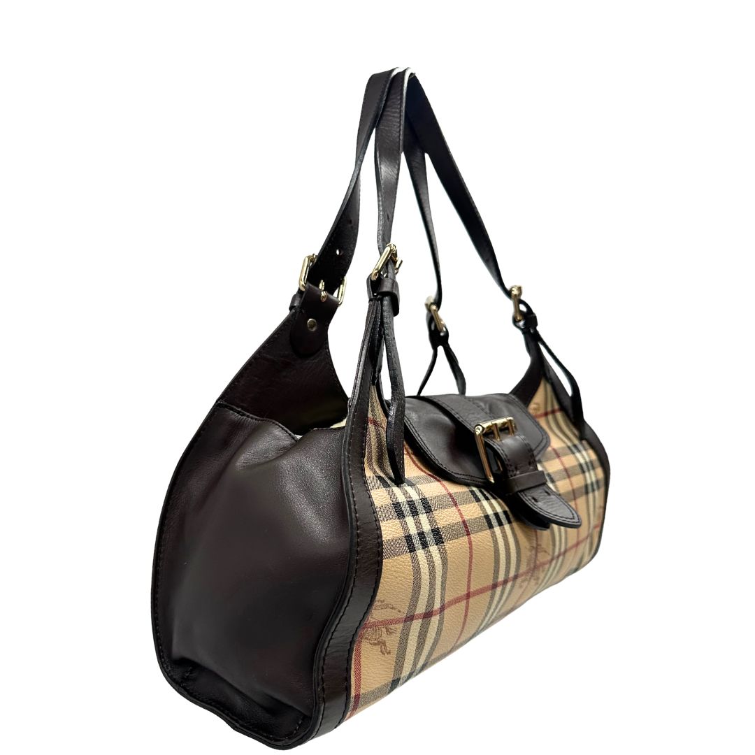 Laterale sinistro di una borsa Burberry in canvas beige, motivo Burberry check, con dettagli e finiture in pelle marroni testa di moro, parti metalliche dorate. Munita di doppi manici leggermente regolabili, indossabile a spalla. Completa di dustbag.