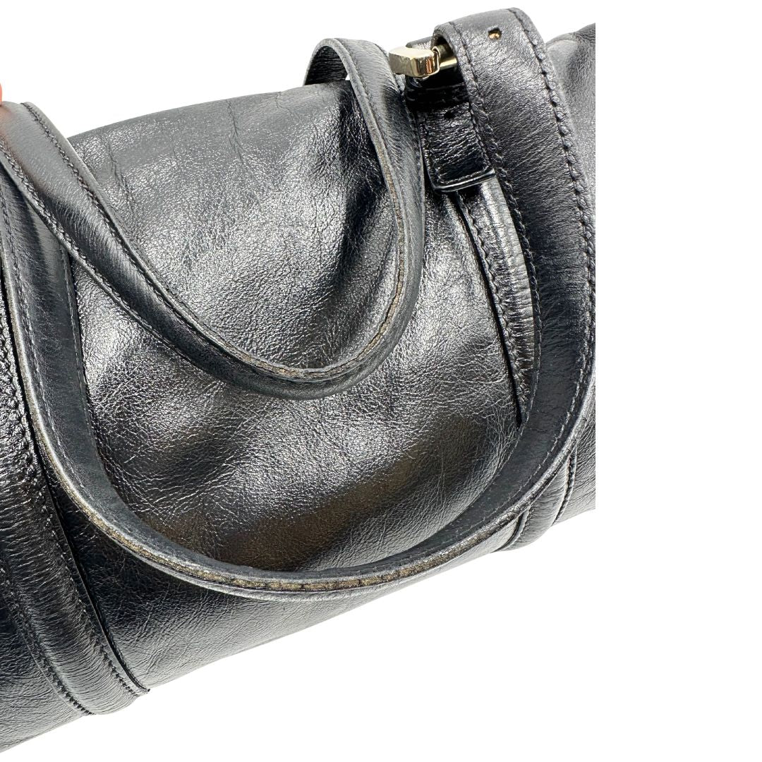 Minici di un Bauletto Gucci Britt Boston in pelle nera con parti metalliche dorate e doppi manici; da indossare a spalla. Rifinita con doppie G incrociate in metallo sul front. Completa di dustbag. Originale, usato, di lusso, in ottime condizioni.