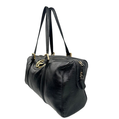 Lato sinistro di un Bauletto Gucci Britt Boston in pelle nera con parti metalliche dorate e doppi manici; da indossare a spalla. Rifinita con doppie G incrociate in metallo sul front. Completa di dustbag. Originale, usato, di lusso, in ottime condizioni.