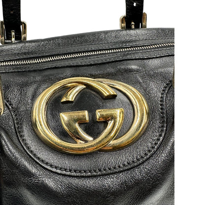 Bauletto Gucci Britt Boston in pelle nera con parti metalliche dorate e doppi manici; da indossare a spalla. Rifinita con doppie G incrociate in metallo sul front. Completa di dustbag. Originale, usato, di lusso, in ottime condizioni.