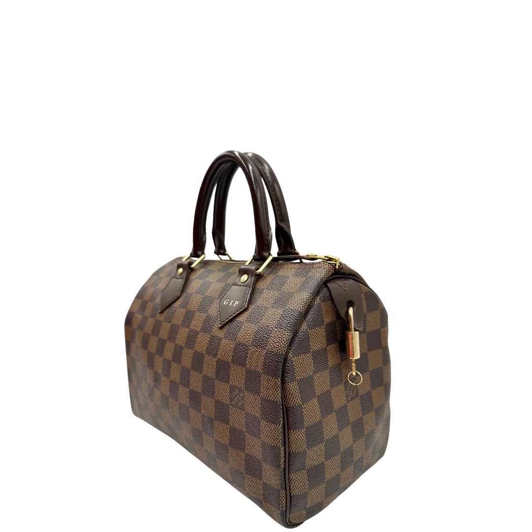 Laterale destro di una borsa Louis Vuitton in canvas Damier Ébène con parti metalliche dorate; munita di doppi manici stondati, da portare a mano. Completo di scatola logata, lucchetto e chiavi.