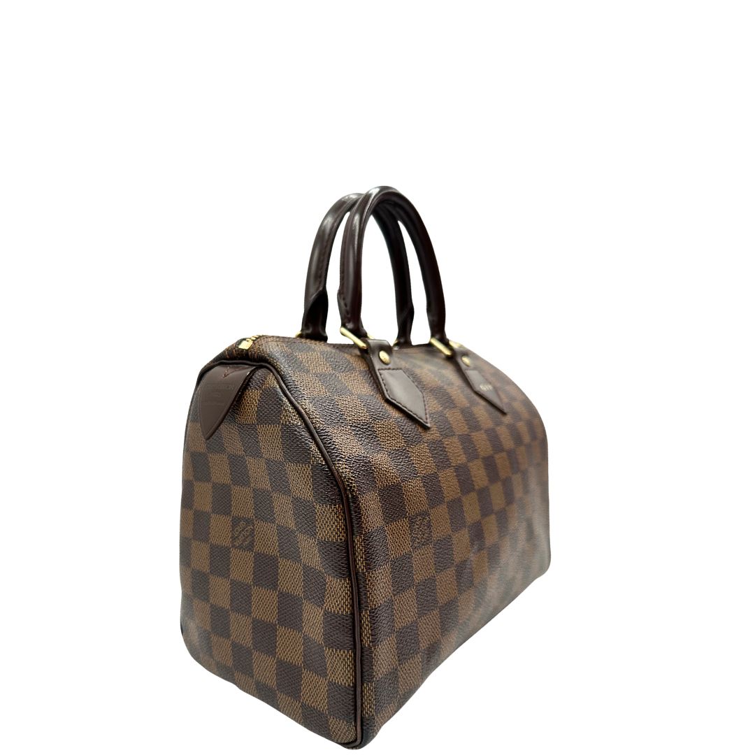 Laterale sinistro di una borsa Louis Vuitton in canvas Damier Ébène con parti metalliche dorate; munita di doppi manici stondati, da portare a mano. Completo di scatola logata, lucchetto e chiavi.