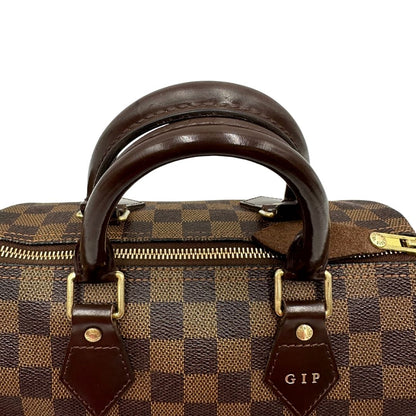 Manici e personalizzazione di una borsa Louis Vuitton in canvas Damier Ébène con parti metalliche dorate; munita di doppi manici stondati, da portare a mano. Completo di scatola logata, lucchetto e chiavi.