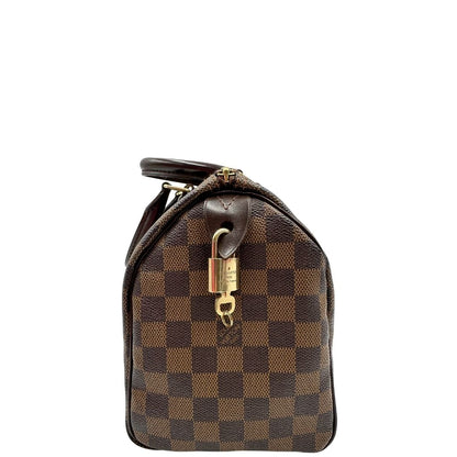 Laterale di una borsa Louis Vuitton in canvas Damier Ébène con parti metalliche dorate; munita di doppi manici stondati, da portare a mano. Completo di scatola logata, lucchetto e chiavi.