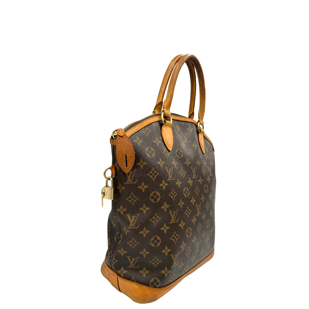 Lato destro di una Borsa Louis Vuitton in canvas marrone monogram con finiture in vacchetta naturale e parti metalliche dorate. Munita di doppi manici stondati. Completa di dustbag, lucchetto e chiavi. Originale, usata, di lusso, in ottime condizioni.