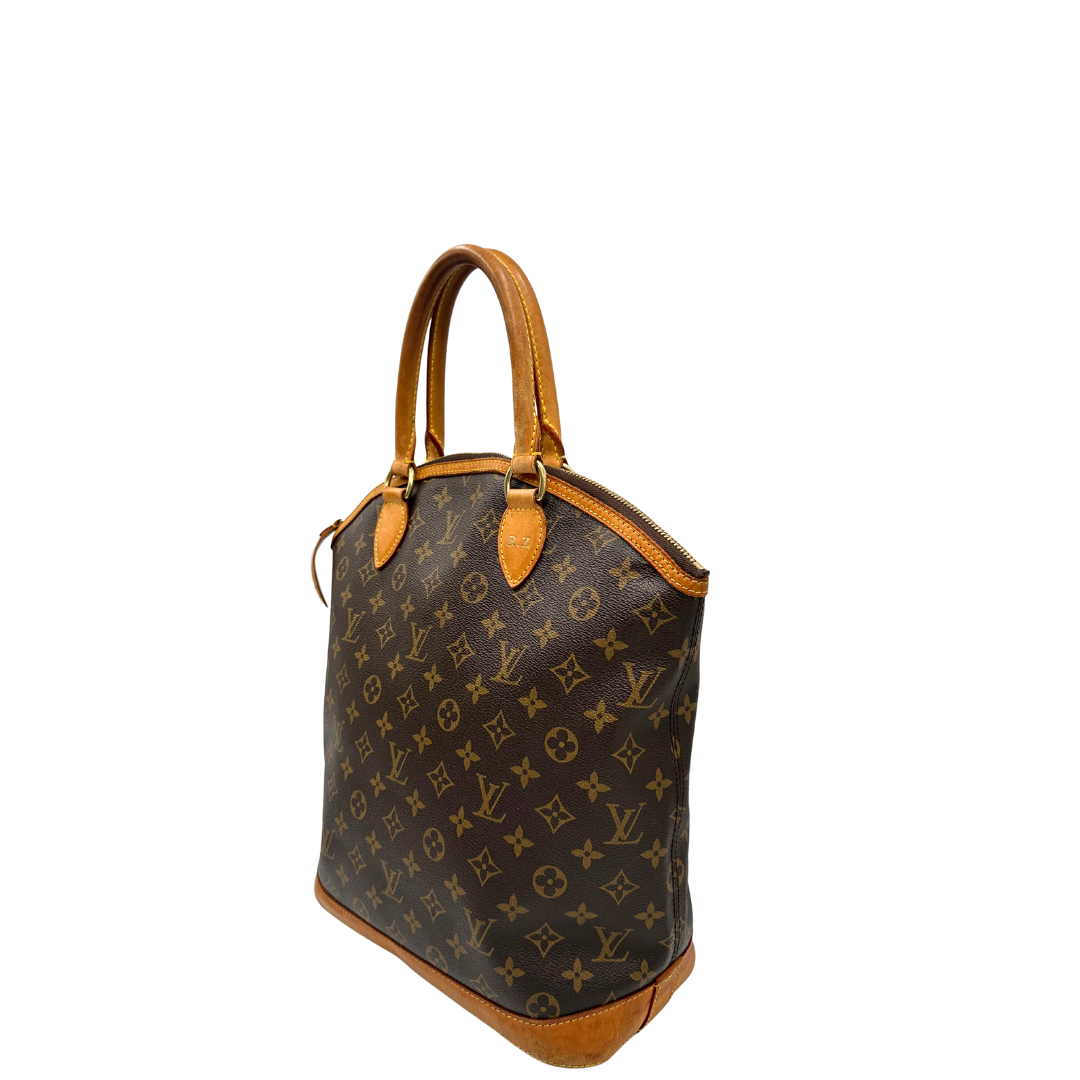 Lato sinistro di una Borsa Louis Vuitton in canvas marrone monogram con finiture in vacchetta naturale e parti metalliche dorate. Munita di doppi manici stondati. Completa di dustbag, lucchetto e chiavi. Originale, usata, di lusso, in ottime condizioni.