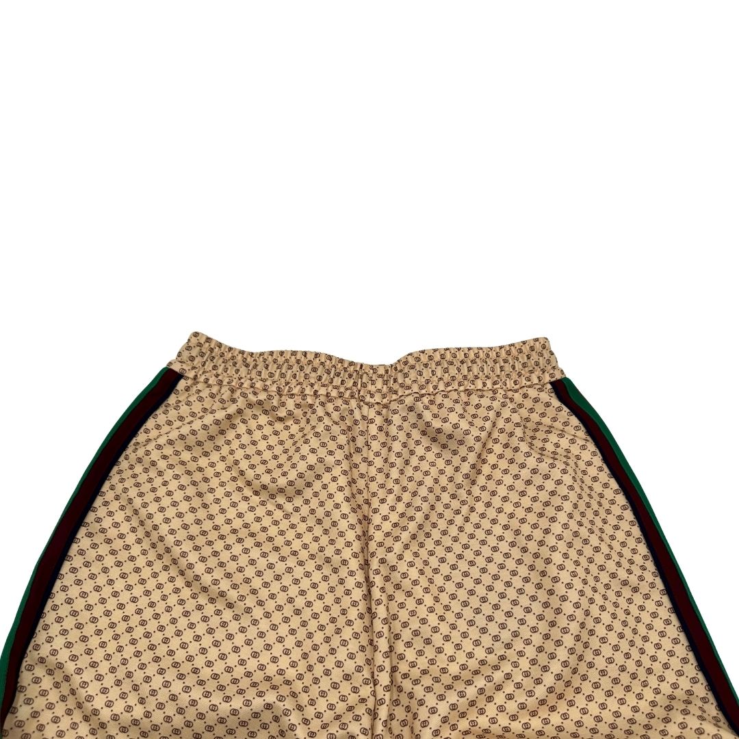 Retro di un pantalone tuta Gucci elasticizzato modello Interlocking G in 55% poliestere e 45% cotone, beige e avorio con motivo micro GG all-over e bande laterali web e fascia elastica sulle estremità.