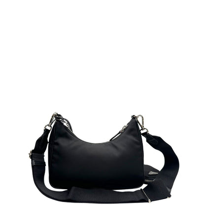 Retro di una borsa Prada in nylon nero con parti metalliche argentate e finiture in pelle tono su tono; munita di una mini pouch amovibile, un accessorio portachiavi, manico in catena e una tracolla in tessuto amovibile e regolabile.