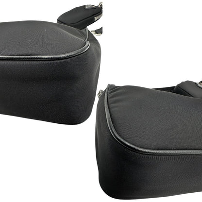 Angoli di una borsa Prada in nylon nero con parti metalliche argentate e finiture in pelle tono su tono; munita di una mini pouch amovibile, un accessorio portachiavi, manico in catena e una tracolla in tessuto amovibile e regolabile.