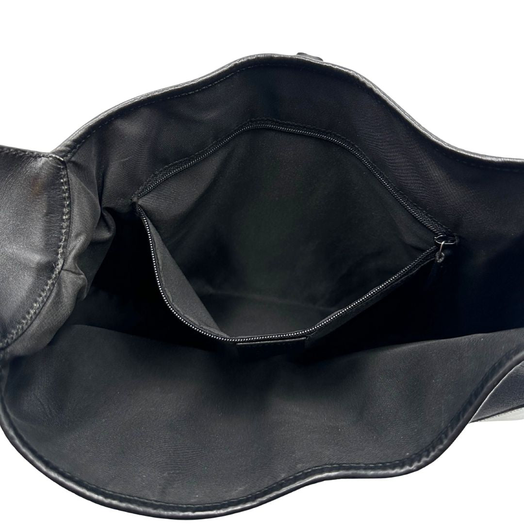 Interno di una borsa Gucci in tessuto nero GG con finiture in pelle tono su tono e parti metalliche argentate. Munita di un manico leggermente regolabile.