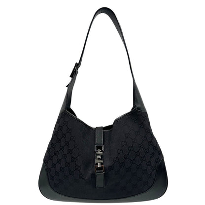 Front di una borsa Gucci in tessuto nero GG con finiture in pelle tono su tono e parti metalliche argentate. Munita di un manico leggermente regolabile.