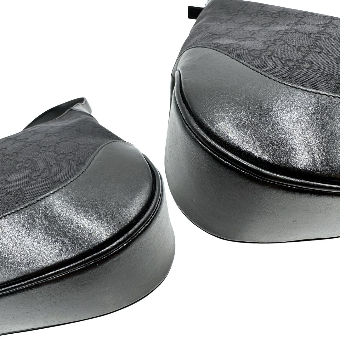 Angoli di una borsa Gucci in tessuto nero GG con finiture in pelle tono su tono e parti metalliche argentate. Munita di un manico leggermente regolabile.