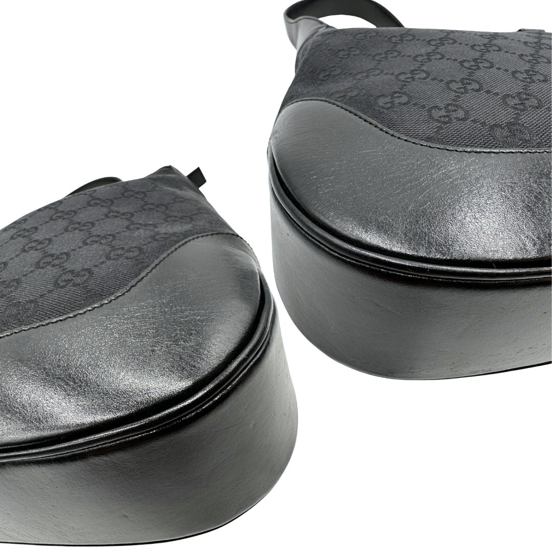 Angoli di una borsa Gucci in tessuto nero GG con finiture in pelle tono su tono e parti metalliche argentate. Munita di un manico leggermente regolabile.