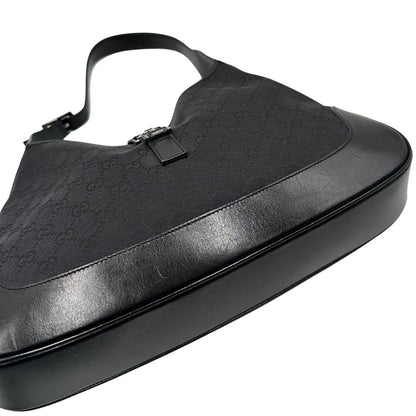 Base di una borsa Gucci in tessuto nero GG con finiture in pelle tono su tono e parti metalliche argentate. Munita di un manico leggermente regolabile.