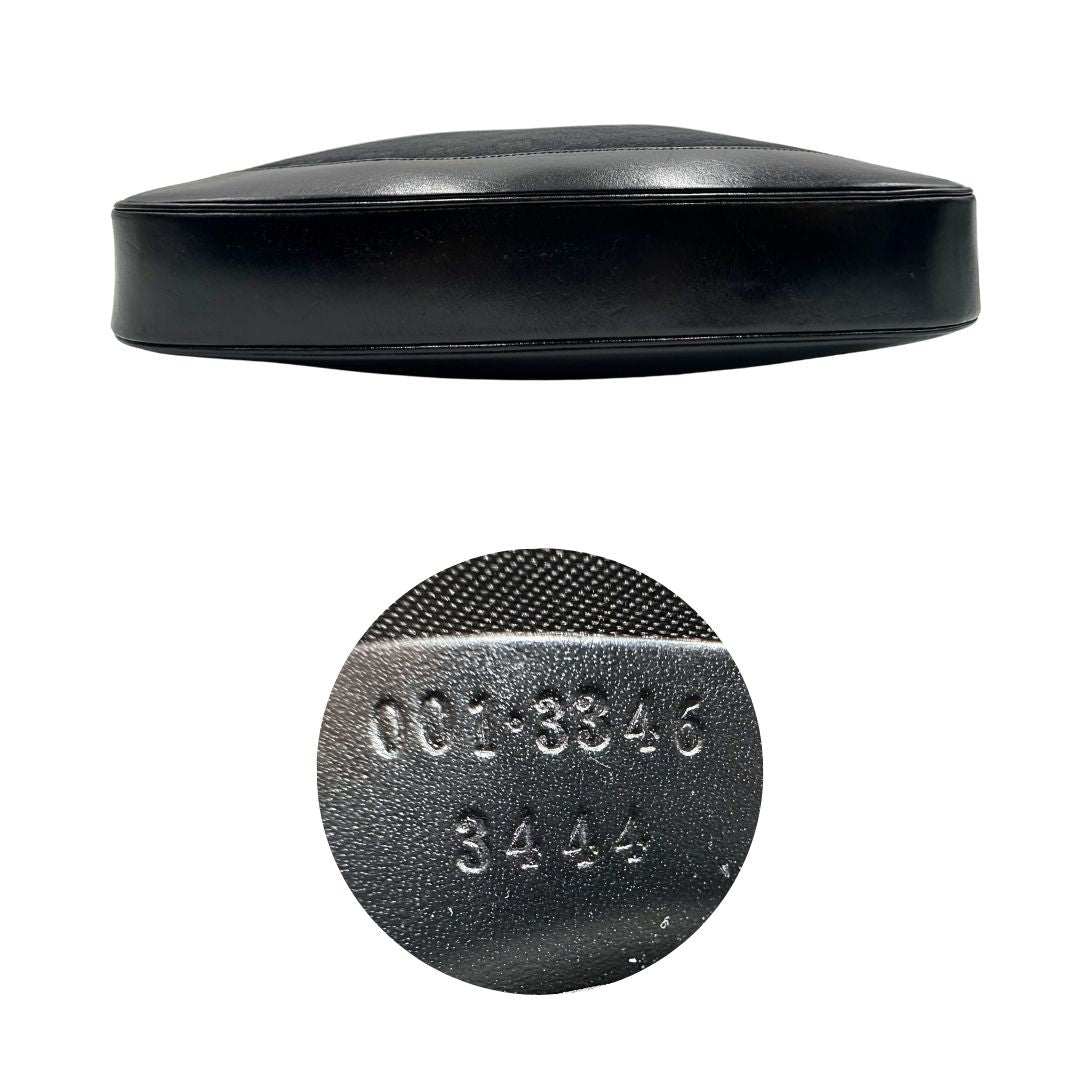 Base e codice di una borsa Gucci in tessuto nero GG con finiture in pelle tono su tono e parti metalliche argentate. Munita di un manico leggermente regolabile.