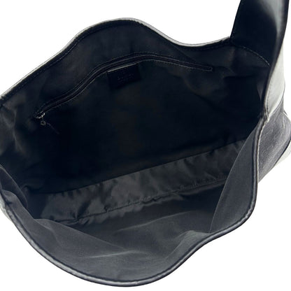 Interno di una borsa Gucci in tessuto nero GG con finiture in pelle tono su tono e parti metalliche argentate. Munita di un manico leggermente regolabile.