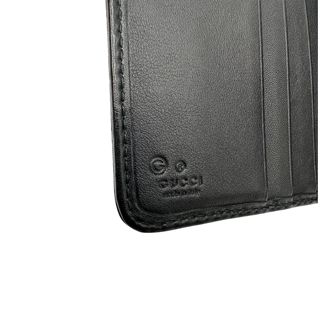 Portafoglio Gucci in pelle nera GG con parti metalliche dorate. Completo di scatola. Originale, usato, di lusso, in ottime condizioni.