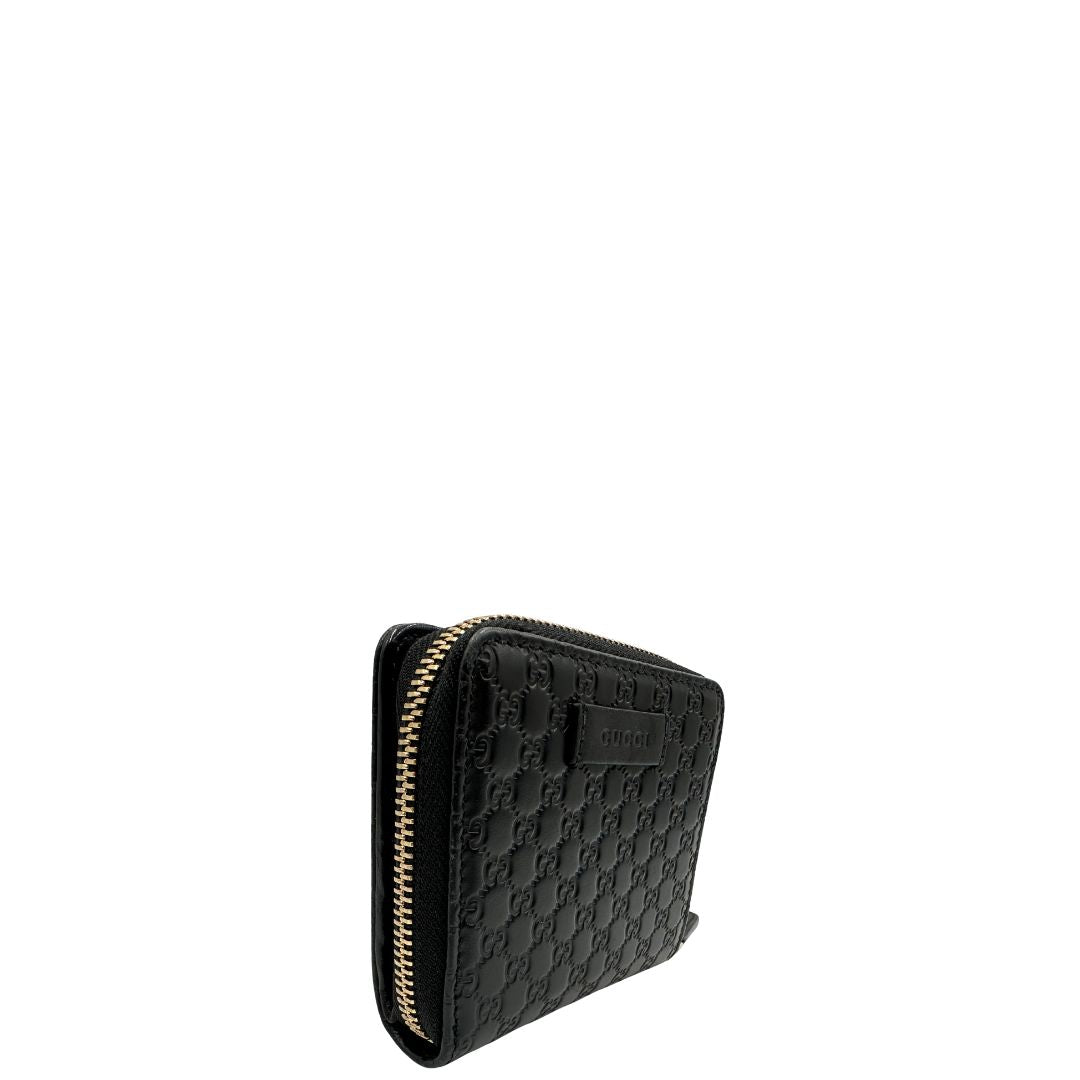 Lato destro di un Portafoglio Gucci in pelle nera GG con parti metalliche dorate. Completo di scatola. Originale, usato, di lusso, in ottime condizioni.