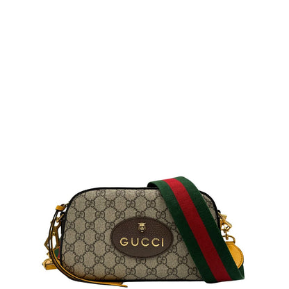 Front di una borsa Gucci Neo Vintage in canvas beige GG Supreme con finiture in pelle marrone e parti metalliche dorate. Munita di una tracolla in tessuto Web verde e rosso, con dettagli in pelle gialla. Rifinita con logo lettering sul front e testa di tigre decorativa. Completa di dustbag.