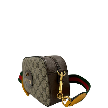 Laterale destro di una borsa Gucci Neo Vintage in canvas beige GG Supreme con finiture in pelle marrone e parti metalliche dorate. Munita di una tracolla in tessuto Web verde e rosso, con dettagli in pelle gialla. Rifinita con logo lettering sul front e testa di tigre decorativa. Completa di dustbag.