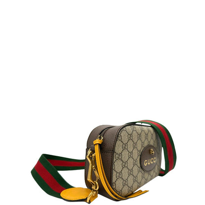 Laterale sinistro di una borsa Gucci Neo Vintage in canvas beige GG Supreme con finiture in pelle marrone e parti metalliche dorate. Munita di una tracolla in tessuto Web verde e rosso, con dettagli in pelle gialla. Rifinita con logo lettering sul front e testa di tigre decorativa. Completa di dustbag.