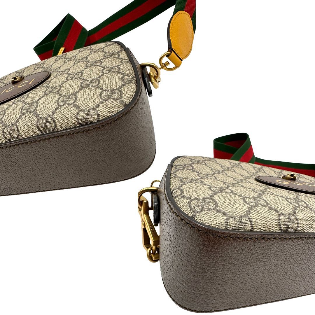 Angoli di una borsa Gucci Neo Vintage in canvas beige GG Supreme con finiture in pelle marrone e parti metalliche dorate. Munita di una tracolla in tessuto Web verde e rosso, con dettagli in pelle gialla. Rifinita con logo lettering sul front e testa di tigre decorativa. Completa di dustbag.