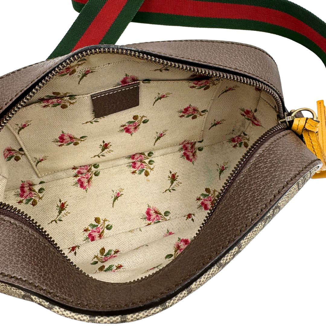 Interno di una borsa Gucci Neo Vintage in canvas beige GG Supreme con finiture in pelle marrone e parti metalliche dorate. Munita di una tracolla in tessuto Web verde e rosso, con dettagli in pelle gialla. Rifinita con logo lettering sul front e testa di tigre decorativa. Completa di dustbag.