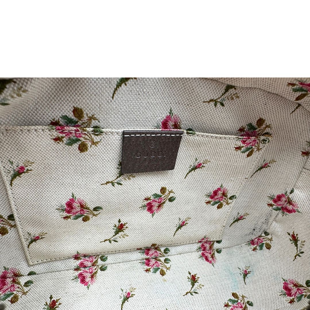 Interno di una borsa Gucci Neo Vintage in canvas beige GG Supreme con finiture in pelle marrone e parti metalliche dorate. Munita di una tracolla in tessuto Web verde e rosso, con dettagli in pelle gialla. Rifinita con logo lettering sul front e testa di tigre decorativa. Completa di dustbag.