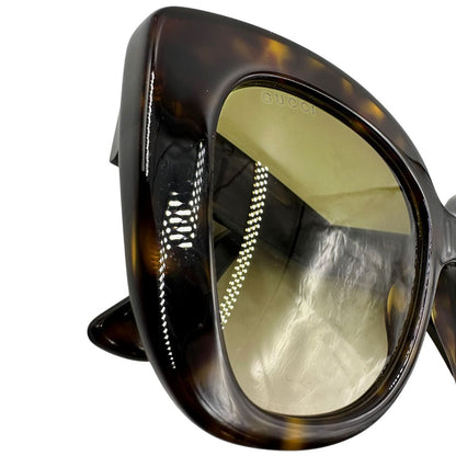 Occhiali da sole Gucci in acetato marrone tartarugato rifiniti con doppie G in metallo dorato sulle asticelle. Completi di custodia e sacchetto protettivo.