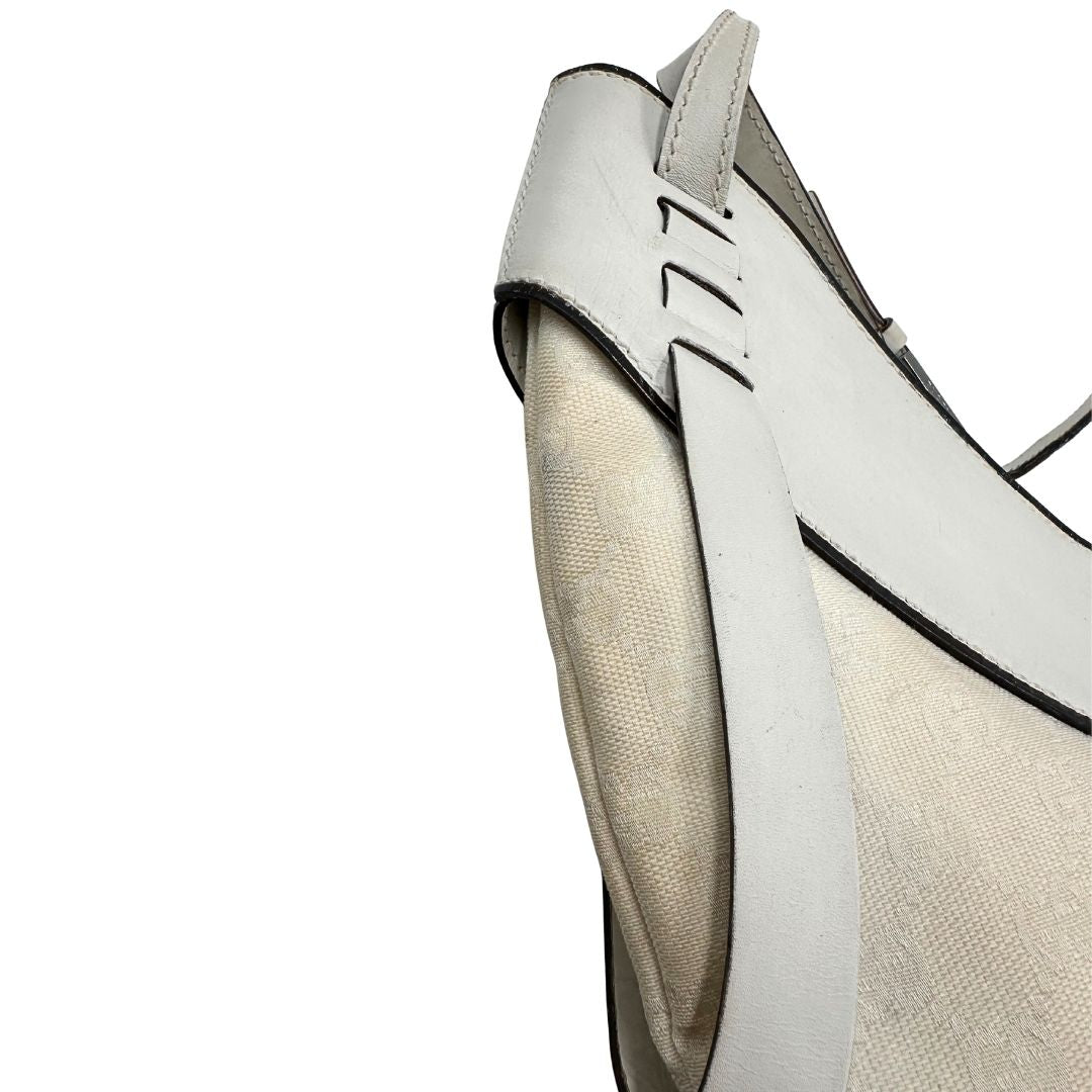Difetti del pellame di una borsa Gucci in tessuto avorio GG con parti in pelle bianco gesso e parti metalliche argentate. Indossabile a spalla.