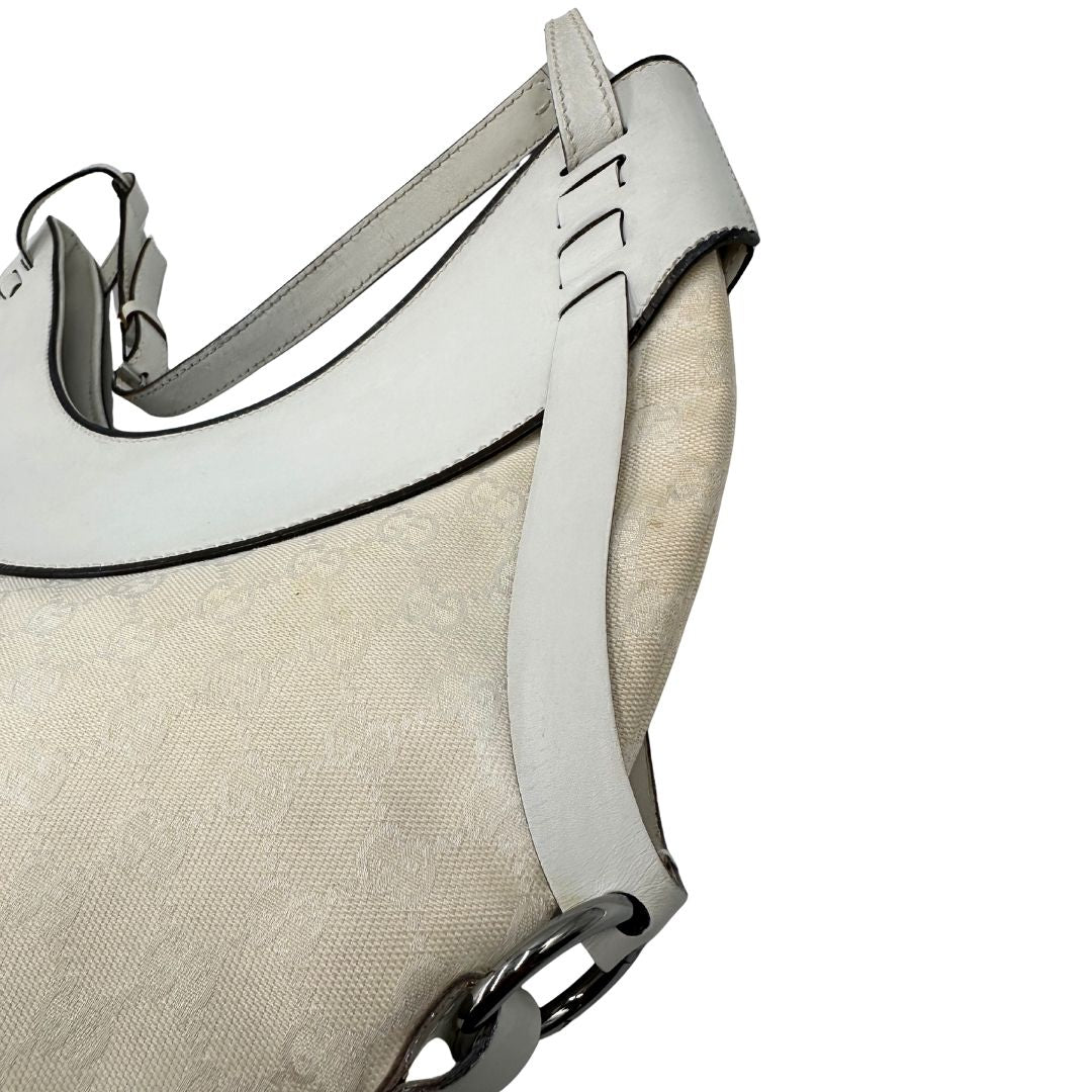 Difetti del pellame di una borsa Gucci in tessuto avorio GG con parti in pelle bianco gesso e parti metalliche argentate. Indossabile a spalla.