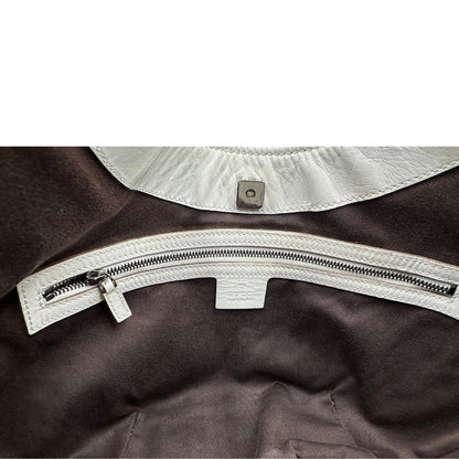 Interno di una borsa Gucci in tessuto avorio GG con parti in pelle bianco gesso e parti metalliche argentate. Indossabile a spalla.