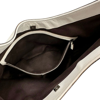 Interno di una borsa Gucci in tessuto avorio GG con parti in pelle bianco gesso e parti metalliche argentate. Indossabile a spalla.