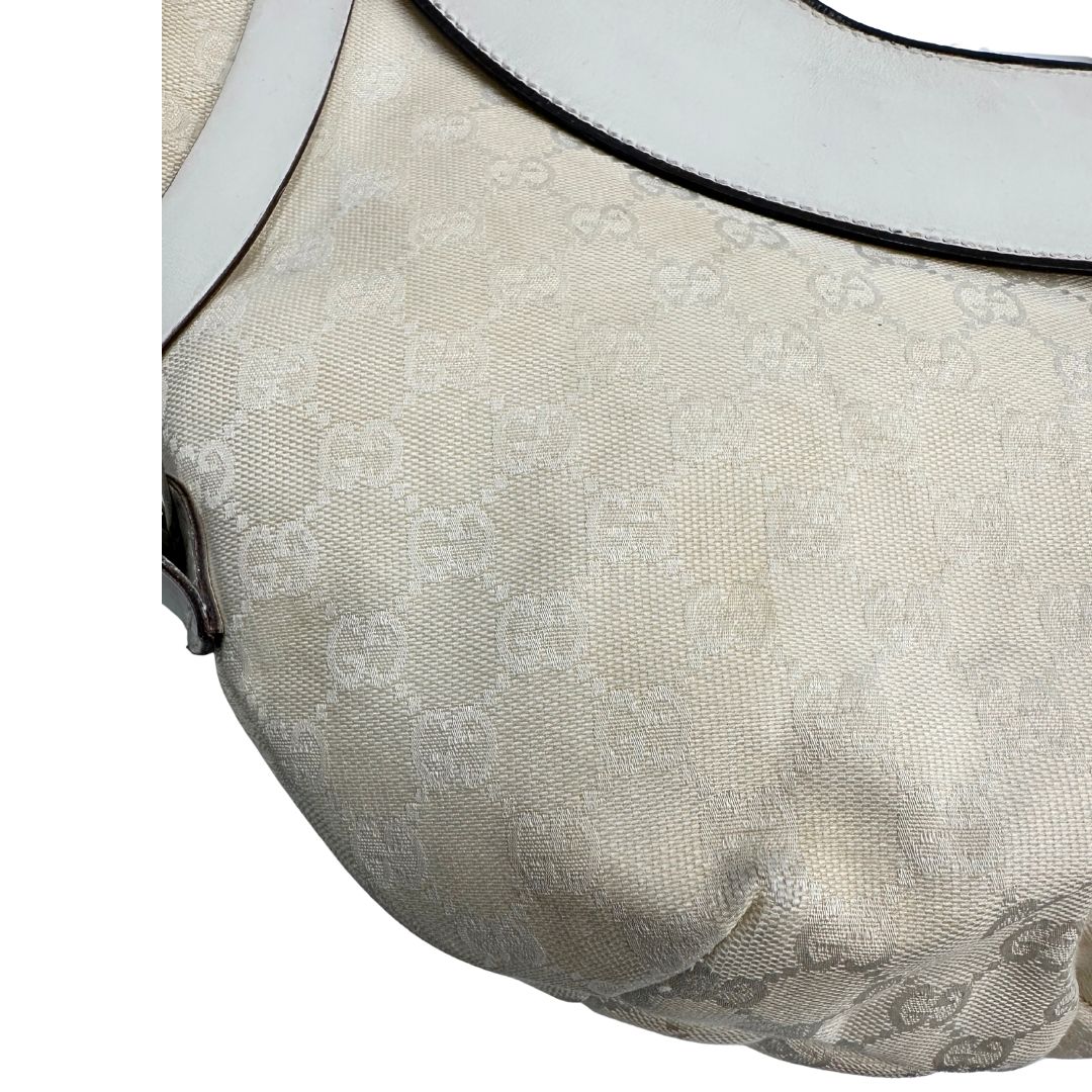 Difetti del tessuto di una borsa Gucci in tessuto avorio GG con parti in pelle bianco gesso e parti metalliche argentate. Indossabile a spalla.