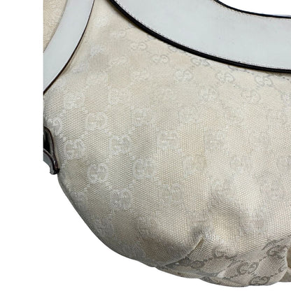 Difetti del tessuto di una borsa Gucci in tessuto avorio GG con parti in pelle bianco gesso e parti metalliche argentate. Indossabile a spalla.