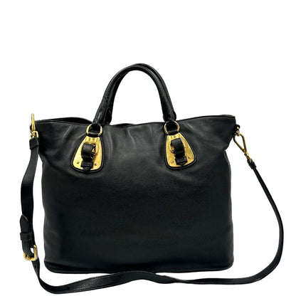 Retro di una borsa Prada in pelle nera con parti metalliche dorate; munita di una tracolla amovibile e regolabile e doppi manici stondati.