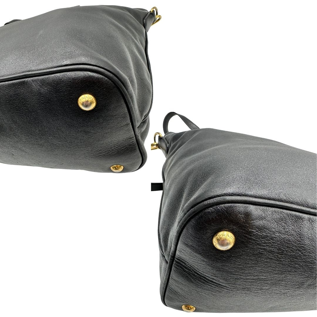 Angoli di una borsa Prada in pelle nera con parti metalliche dorate; munita di una tracolla amovibile e regolabile e doppi manici stondati.