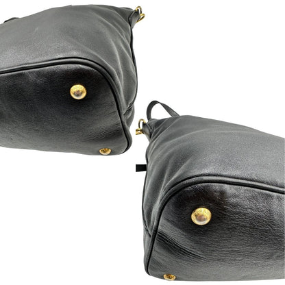 Angoli di una borsa Prada in pelle nera con parti metalliche dorate; munita di una tracolla amovibile e regolabile e doppi manici stondati.