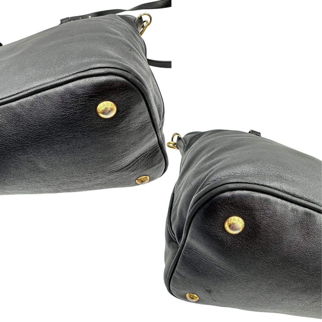 Angoli di una borsa Prada in pelle nera con parti metalliche dorate; munita di una tracolla amovibile e regolabile e doppi manici stondati.