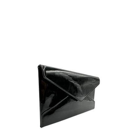 Laterale sinistro di una pochette Paloma Envelope Saint Laurent in vernice nera lucida con chiusura a bottone a pressione e parti metalliche dorate. Interno in pelle con logo impresso. Completa di scatola e sacchetto antipolvere.