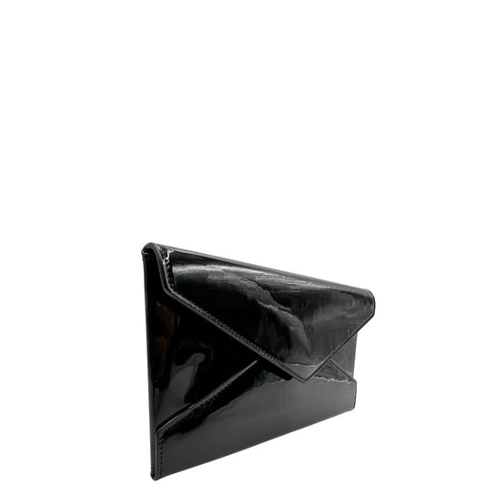 Laterale sinistro di una pochette Paloma Envelope Saint Laurent in vernice nera lucida con chiusura a bottone a pressione e parti metalliche dorate. Interno in pelle con logo impresso. Completa di scatola e sacchetto antipolvere.